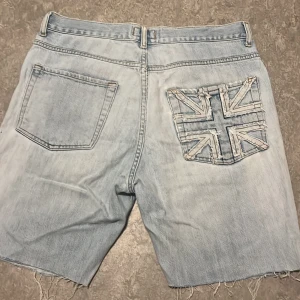 Snygga jeans shorts - Snygg design i bak. Klippta själv med lite distressing. Passar typ 31-32 i midjan.  Ytterben~ 48,5cm Innerben~ 21,5cm