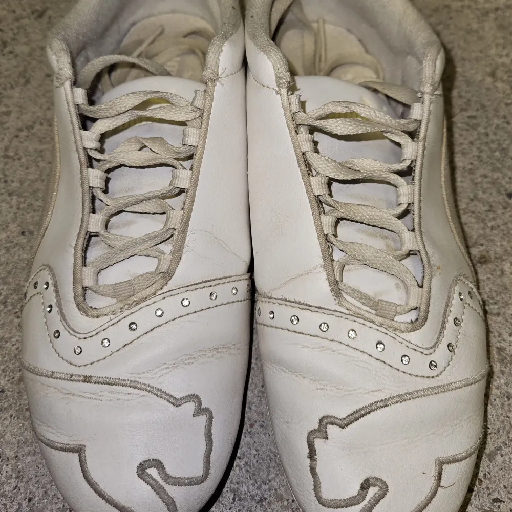 Supersköna vita sneakers från Puma. Fina detaljer med kristaller! Fint skick, inga hål och alla kristaller är kvar! Äkta läder!. Skor.