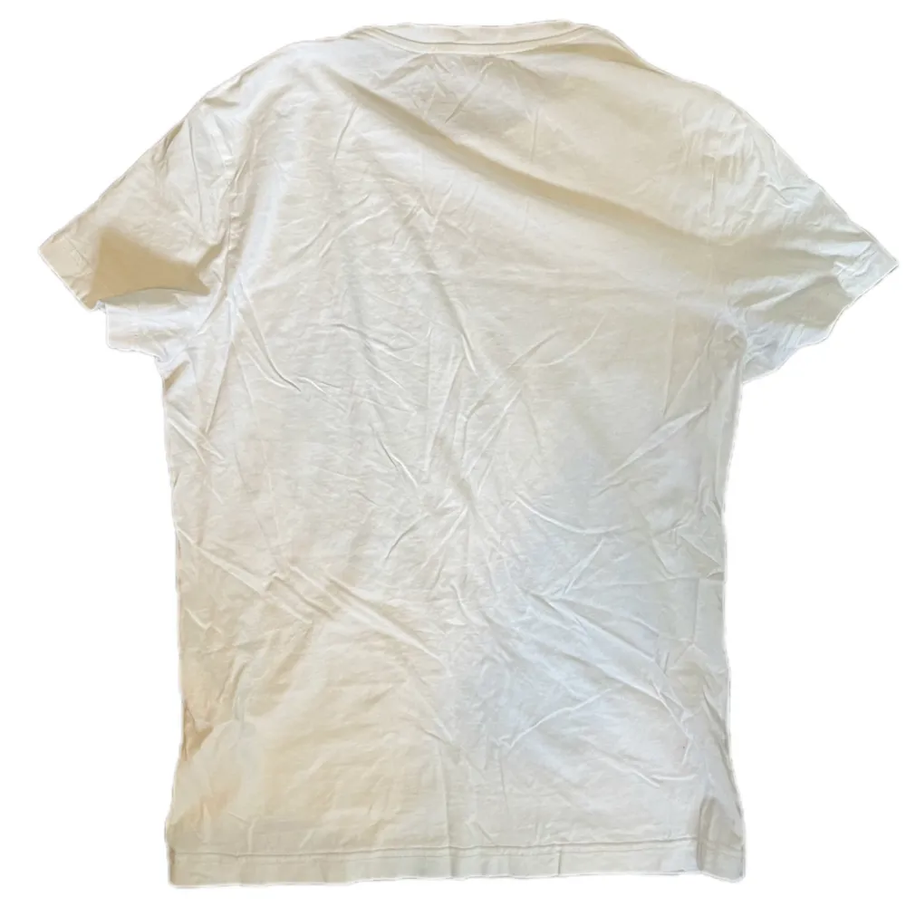 en vit versace t-shirt med tryck storlek S i bra skick, lite urtvättad men annars bra. T-shirts.
