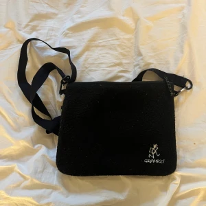 Gramicci väska  - Svart lurvig gramicci bag köpt på SNS i Stockholm! Har dragkedja axelband man kan reglera rymmer rätt mycket ! 