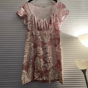 Klänning - Fin sommar klänning, rosa med vita blomavtryck. Den är rätt kort, så jag har haft en vit kjol under. 