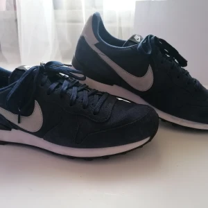 Nike skor - Säjer nästan oanvända mörkblåa nike skor i strl. 42,5 De är vattentäta och fungerar perfekt vid flera sammanhang. 