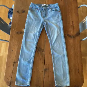 Ljusblåa levis jeans i bra skick, den bruna lappen på baksidan an jeansen är lite sönder men annars är dem i väldigt på skick