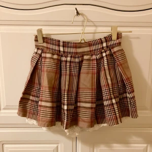 Rutig Liz Lisa skort / kjol  - Jättefin mini gyaru skort / kjol med shorts från Liz Lisa 🤎 Säljer pga för liten för mig - upplevd storlek 34/36 XXS/XS. Skriv vid frågor 🤎