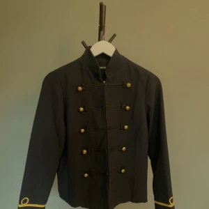 Mörkblå kavaj/jacka med dekorationer  - Mörkblå kavaj med snördekorationer och guldknappar. Inspirerad av Sgt Pepper, Michael Jackson, Prince.