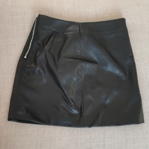 Fusk läder kjol  - Endast testad lappen sitter kvar. Stl 38  Katt finns i hemmet 