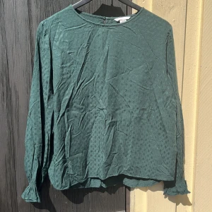 Mönstrad blus - Grön mönstrad blus med volangärm och liten nyckelhålsstängning i nacken. Bra skick och 100% viskos  