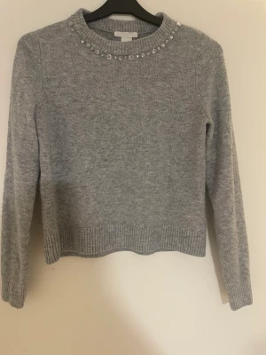 Grå stickad tröja  - En jättefin och mysig grå stickad tröja från H&M. Inga stora täckningar på användning och inga stenar som har trillat av. Tröjan är i stl XS och passar bra med nästan allt, kostade  200kr och säljer den för 50kr. Men va inte blyga med att föreslå ett pris