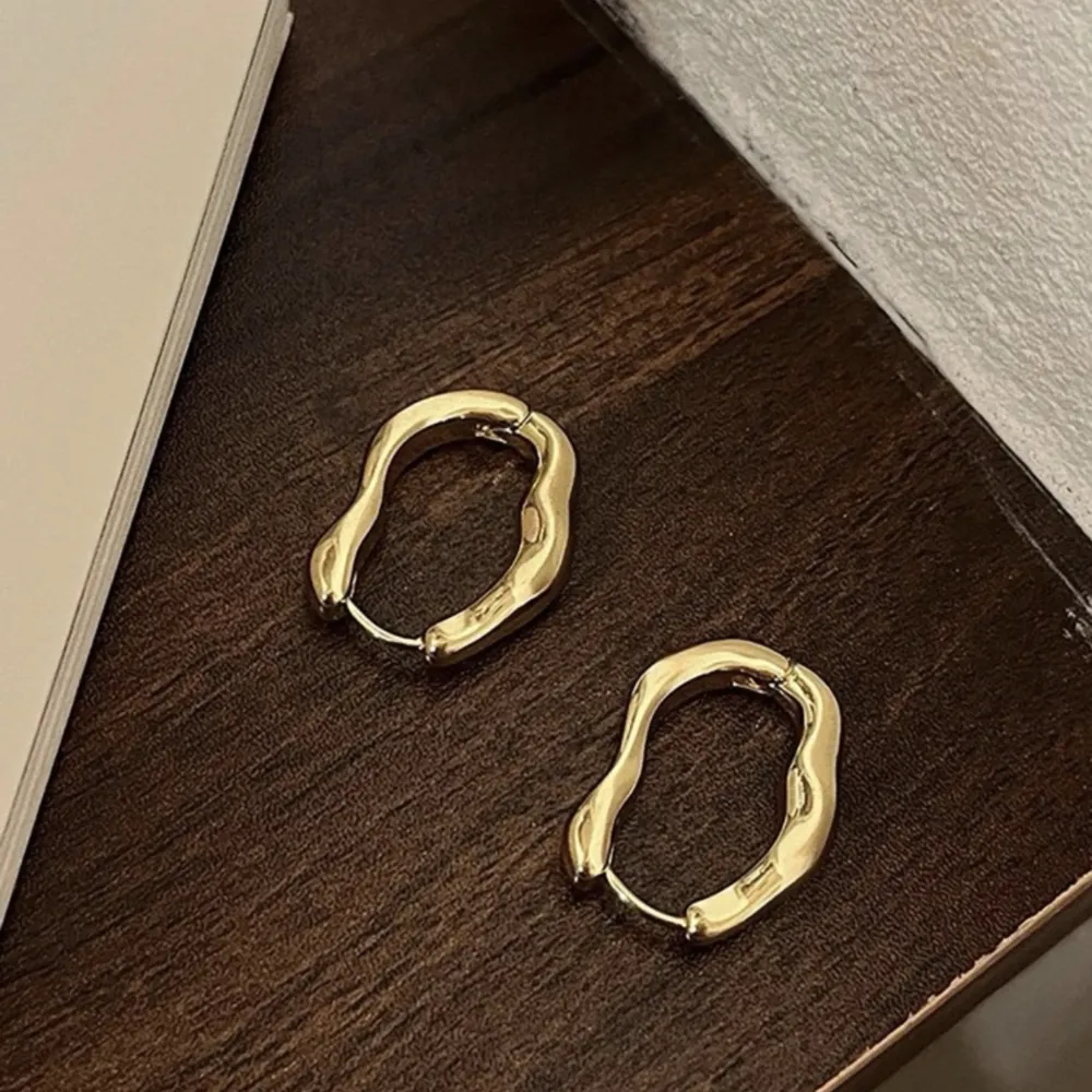 Asymmetriska örhängen i guld. Accessoarer.