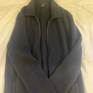 Zip-up cardigan Massimo Dutti - En stilren zip-up cardigan från Massimo Dutti i storlek M. Nypriset är 600kr. Plagget är nopprigt, mest vid ärmarna-därav prisreducering. Annars är plagget i ett fint skick. Tveka inte på att kontakta mig vid ev. frågor!  Samfrakt erbjuds!