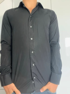 Svart skjorta från Eton - Svart skjorta från Eton. Strl 38/S. Inga defekter. Modellen är 178 cm och väger 77 kg. Hör gärna av dig vid frågor!