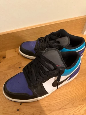 Air Jordan 1 Low Aqua sneakers - Snygga Air Jordan 1 Low 'Aqua' sneakers med svart, vit, blå och turkos färgkombination. Skorna har klassisk låg siluett, svart Swoosh och snörning. Ovandelen är i läder och textil, med vadderad häl och vit mellansula. Perfekta för dig som gillar streetwear. De har varit använda, men nu har de inte används på länge, därför säljer jag dem. De är fortfarande i en bra condition och var köpta för 1400kr💜