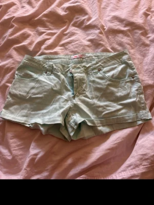 Turkos shorts från FB Sister - Snygga turkos färgade  shorts från FB Sister med klassisk femficksmodell och dragkedja framtill. Shortsen har en midwaist passform och är tillverkade i mjuk bomull, perfekta för varma dagar.