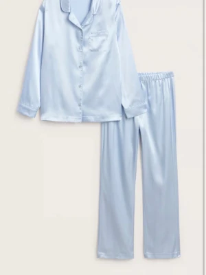 Ljusblå satinpyjamas med lång ärm - Snygg ljusblå pyjamas i satin med långärmad skjorta och matchande byxor. Skjortan har knappar framtill, bröstficka och klassisk krage. Byxorna har resår i midjan för extra komfort. Perfekt för mysiga kvällar hemma. Helt ny med lappen på. 