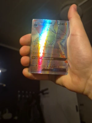 Pokémonkort Vikavolt GX holo - Säljer ett Pokémonkort av typen Vikavolt GX med holografisk yta. Kortet har färger i blått, silver och regnbågsskimrande toner. Perfekt för samlare eller Pokémonfans som vill utöka sin samling med ett coolt GX-kort.