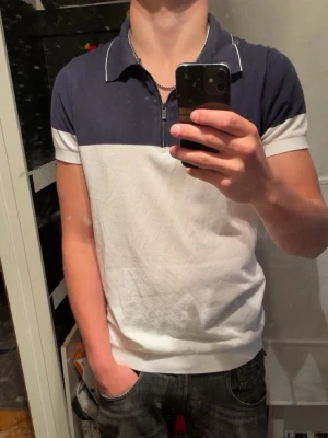 Blåvit piké från Massimo Dutti - Säljer en stilren blåvit piké från Massimo Dutti. Perfekt för dig som vill ha en mer laidback still till sommaren. Modellen är 170cm och väger 64kg.