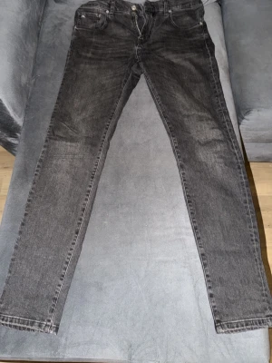 J.Lindeberg "Jay" Jeans – Grå/Svart stentvätt (Fint skick!) - Säljer ett par snygga och stilrena jeans från J.Lindeberg i modellen "Jay". Jeansen har en modern, mörkgrå/svart stentvättad färg som passar till allt.Märke: J.LindebergModell: Jay  (Mid-Rise / Slim Fit)Färg: Grå / Svart.   stentvättSkick: Mycket fint begagnat skick. Inget grovt slitage, hela och rena.Storlek: [Fyll i storlek här, t.ex. W32/L32 – lappen sitter på insidan eller baksidan av linningen]