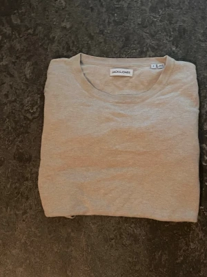 Beige tröja från Jack & Jones - En stilren beige tröja från Jack & Jones med rund halsringning och långa ärmar. Tröjan är tillverkad i ett mjukt material och har ribbade muddar vid ärmslut och nederkant. Perfekt för en enkel och clean look.