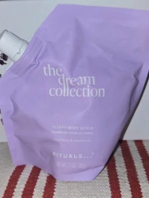 Rituals Fluffy Body Scrub Dream Collection - Ljuslila påfyllningspåse med Rituals Fluffy Body Scrub från The Dream Collection. Innehåller 220 g och har doft av blue daisy och moonstone. Praktisk förslutning och mjuk plastförpackning, perfekt för exfoliering av kroppen.
