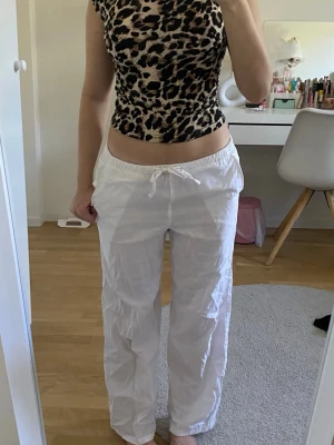 Vita linnebyxor - Säljer ett par vita linnebyxor med avslappnad passform och dragsko i midjan. Byxorna har raka ben och elastisk midja för extra komfort. Perfekta för en chill och luftig stil under varma dagar.