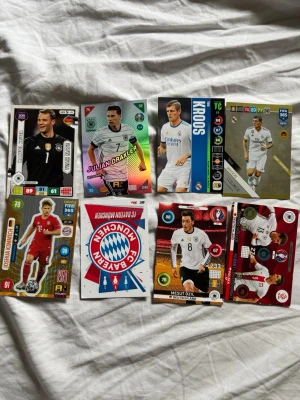 Samling fotbollskort Tyskland & Bayern - Säljer en samling fotbollskort med tyska spelare och Bayern München-tema. Korten har färgstarka tryck, olika former och motiv på spelare som Kroos, Draxler och Özil. Perfekt för dig som gillar samlarkort och fotboll. Materialet är glansig kartong. Perfekt för dig som tycker om föredettingar inom fotbollen som har haft sin otroliga prime.