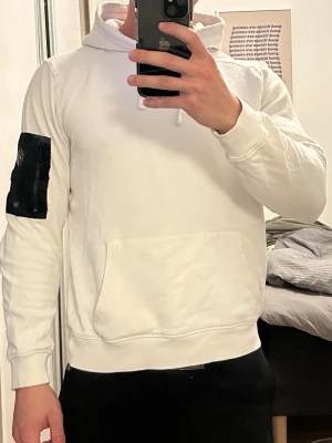 Vit hoodie från Snoot. - Hoodie från Snoot med svart ficka på armen. Använd men i bra skick. Normalstor i storleken.