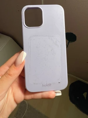 Ljuslila mobilskal från Holdit - Snyggt ljuslila mobilskal från Holdit med stilren design. Skalet är gjort i ett mjukt och greppvänligt material som skyddar mobilen mot repor och stötar. Passar perfekt för dig som vill ha ett enkelt men trendigt skydd till din telefon. Passar till en IPhone 12. 
