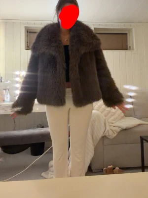 Brun fluffig pälsjacka - Säljer en brun, fluffig pälsjacka med bred krage och långa ärmar den är ganska stor i stoleken . Jackan har en oversized passform och är perfekt för kalla vinterdagar. Materialet är mjukt och ger en lyxig känsla. Enkel att styla till olika outfits.