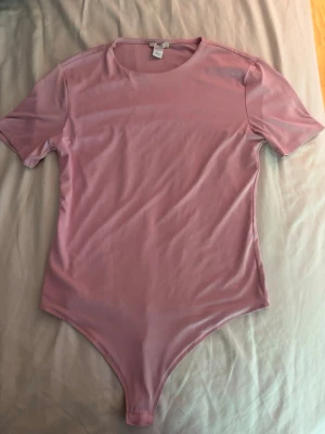 Body  - En ros body som är jätte gullig och passar med allt. Jag har köpt den på Vinted men står att den är ifrån amisu i storlek L. Jag säljer denna för tyckte den satt lite pösigt på mig och jag har för mycket kläder. Den är i bra skick med vet inte hur mycket förra ägaren använde den💕