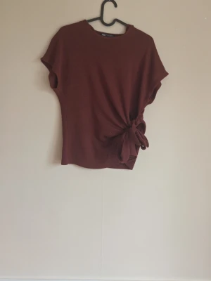 Trendig zara tröja - En snygg och trendig tröja från Zara med en rosett på sidan. Tröjan är i ett mycket gott skick och är storlek S.