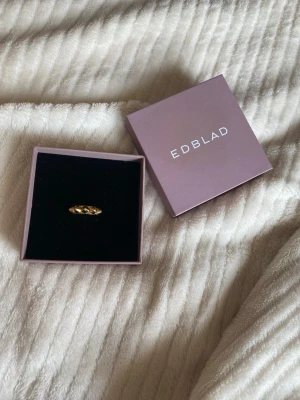 Guldfärgad ring från Edblad - Snygg guldfärgad ring från Edblad med pyramidformade detaljer runt hela ringen. Ringen har en modern och edgy design som sticker ut och passar perfekt för dig som gillar stockholmsstilssmycken.
