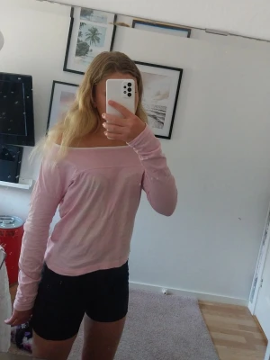Ljusrosa offshoulder topp - Säljer en ljusrosa offshoulder topp med lång ärm. Toppen har en enkel och clean design med rak skärning upptill och är tillverkad i mjukt bomullstyg. Perfekt för dig som gillar en avslappnad men ändå snygg stil. På framsidan av tröja står det 68. Det är storlek 150 men den är större än 150