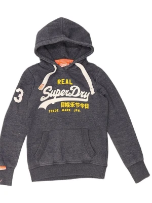 Mörkgrå hoodie från Superdry - Mörkgrå hoodie från Superdry med vit och gul logga framtill, stor ficka och vit dragsko i huvan. Snygg detalj med siffran 3 på ärmen. Tillverkad i bomull och polyester för en mjuk och skön känsla Storlek  S. Liten liten defekt nere på ena ärmen syns inte särskilt mycket och man tänker inte på det men därför de billiga priset 