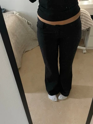 Svarta bootcut kostymbyxor - Säljer ett par svarta kostymbyxor med bootcut passform och låg midja. Byxorna har klassisk look med knapp och dragkedja framtill. Perfekta till en stilren outfit och passar till många olika tillfällen. Aldrig använda och i nyskick! nypris är 200 så säljer för 180. 