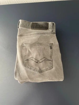 Grå jeans från Replay - Snygga grå jeans från Replay med klassisk femficksdesign och diskret logga på fickan. Jeansen har raka ben och är tillverkade i mjukt denimtyg som ger en skön passform. Perfekta för dig som gillar en stilren och avslappnad look. Hör av dig om du behöver veta något om varan eller om du har några frågor MVH. Vincent