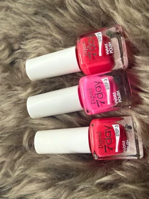 Depend 7day nagellack rosa/röd - Tre snygga Depend 7day Hybrid Polish nagellack i 2 olika nyanser av rosa och rött. Flaskorna har vit kork och tydlig märkning med 'STEP 3'. Perfekt för dig som vill ha hållbara och glansiga naglar med salongskänsla hemma.