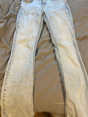 Ljusblå bootcut jeans med stora fickor - Säljer ett par ljusblå jeans med raka ben och stora bakfickor. Jeansen har klassisk femficksdesign och är gjorda i denim. Perfekta för en avslappnad och trendig look.