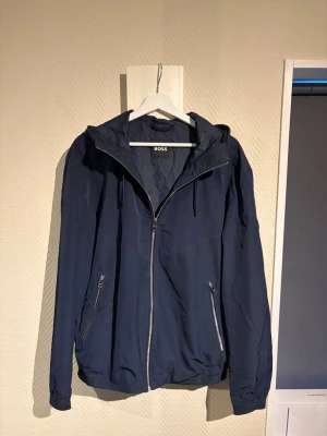 Windbreaker - Tjena! Säljer denna extremt snygga windbreaker från Hugo Boss. Storlek L och i princip nyskick. Nypris 4000! Priset är ej hugget i sten så hör av dig vid minsta fundering:)