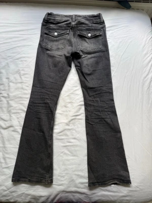 Mörkgrå bootcut jeans  - Säljer ett par grå bootcut jeans i strl XS från Gina tricot. De ätr tillverkade i ett mjukt denimtyg med lätt stretch, vilket gör att midjemåttet kan anpassas och passa massa storlekar! Jag skulle säga att jeansen är lite mörkare i verkligheten än på bilderna.                                                                              Perfekta inför hösten!                                               Pris kan absolut diskuteras!💕