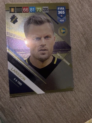 FIFA 365 samlarkort Sebastian Larsson - Samlarkort från FIFA 365-serien med Sebastian Larsson. Kortet har guldiga och svarta detaljer, spelarens namn, födelsedatum och klubbmärke. Perfekt för dig som gillar fotboll och att samla på unika sportkort.