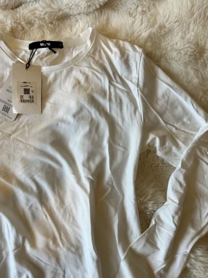 Vit långärmad t-shirt  -  vit långärmad t-shirt från Bik Bok i mjuk bomull. Enkel och stilren, helt ny!!🤩