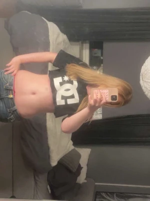 Svart croppad DC topp - Säljer en svart croppad topp från DC med stor vit logga framtill. T-shirten har korta ärmar och är perfekt för dig som gillar streetwear och vill ha en avslappnad men edgy,XS till S