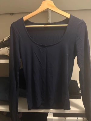 Mörkblå långärmad topp -  Mörkblå långärmad tröja från Gina tricot. En enkel och stilren mörkblå topp med lång ärm och rundad urringning.  Tillverkad i mjukt material som känns skönt mot huden. I super fint skick!