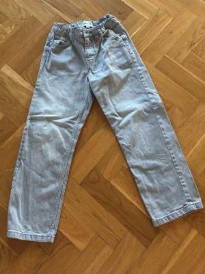 Ljusgråa  jeans med resårmidja i samma modell som dom jag la ut innan.  - Säljer ett par ljusgråa jeans med resår i midjan. Jeansen har klassiska fickor fram och bak samt bälteshällor. Perfekta för en avslappnad och trendig look. Jeansen är ifrån Ullared i stl 134, använd fåtal gånger. Så i jättefint skick. 