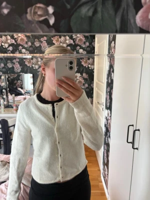 Vit kofta från Gina Tricot - Mysig vit kofta från Gina Tricot med rund halsringning och knappar framtill. Koftan har en mjuk, lite luddig struktur och långa ärmar. Knappt använd super bra skick 🌸