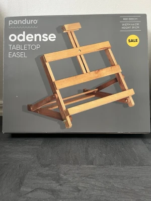 Bordstaffli Odense från Panduro - Säljer ett bordstaffli Odense från Panduro i röd bok. Staffliet är 44 cm brett och 39 cm högt, perfekt för att måla eller ställa upp tavlor på skrivbordet. Snygg och stabil design i trä som passar både till hobby och konstprojekt.