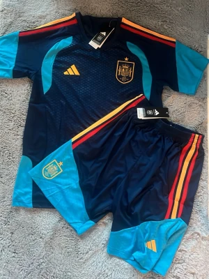 Spanien 26/27 tränings kit  - Ett Spanien tränings kit 26/27 med T-shirt + shorts med fickor! Storlek L helt nytt