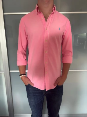 Rosa skjorta - Säljer en riktigt go rosa Ralph lauren skjorta. Riktigt go att ha på sommarn men även på vintern. Killen på bilden är 178cm och väger 72kg.