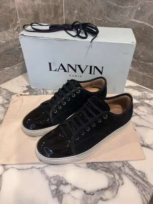 Lanvins  - Lanvins med glans I navy. Skorna är i storlek uk10 vilket motsvarar ungefär 44. Välldigt fint skick, skorna kommer med låda, påse och extra snören