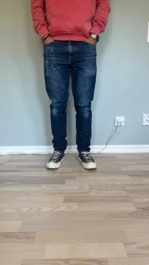 Levi's 512 Slim Taper W30 L30 – Mörkblå | Vintage wash - LEVI’S 512 SLIM TAPER  Storlek: W30 L30 Passform: Slim taper — sitter slim vid låret och smalnar av mot foten Färg: Mörkblå med naturlig vintage wash  512:an är Levi’s slim taper-modell — en modernare passform än 501:an med smalare ben som sitter snyggt utan att vara skinny. Mörkblå tvätt med subtil fading som funkar till det mesta.  Modellen på bilden är 175 cm och väger 65 kg — jeansen sitter tajt och modernt längs benet.  Skick: Mycket bra skick utan defekter. Nypris: ca 1 099 SEK